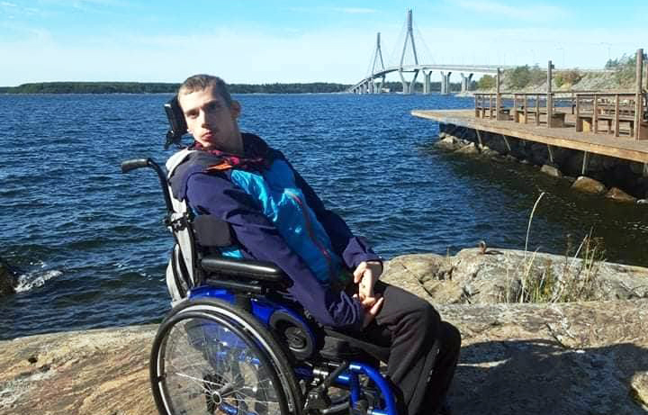Tobias Ståhl pyörätuolissa meren rannalla.