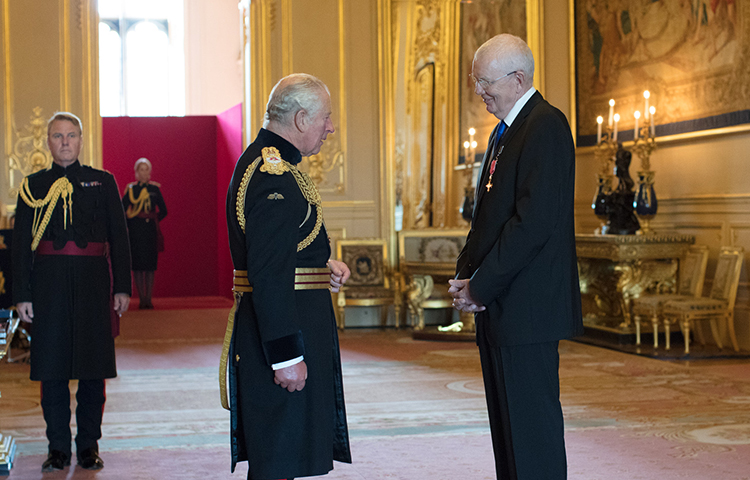 Walesin prinssi Charles ja Dave Hewett keskustelevat Windsorin linnan salissa.
